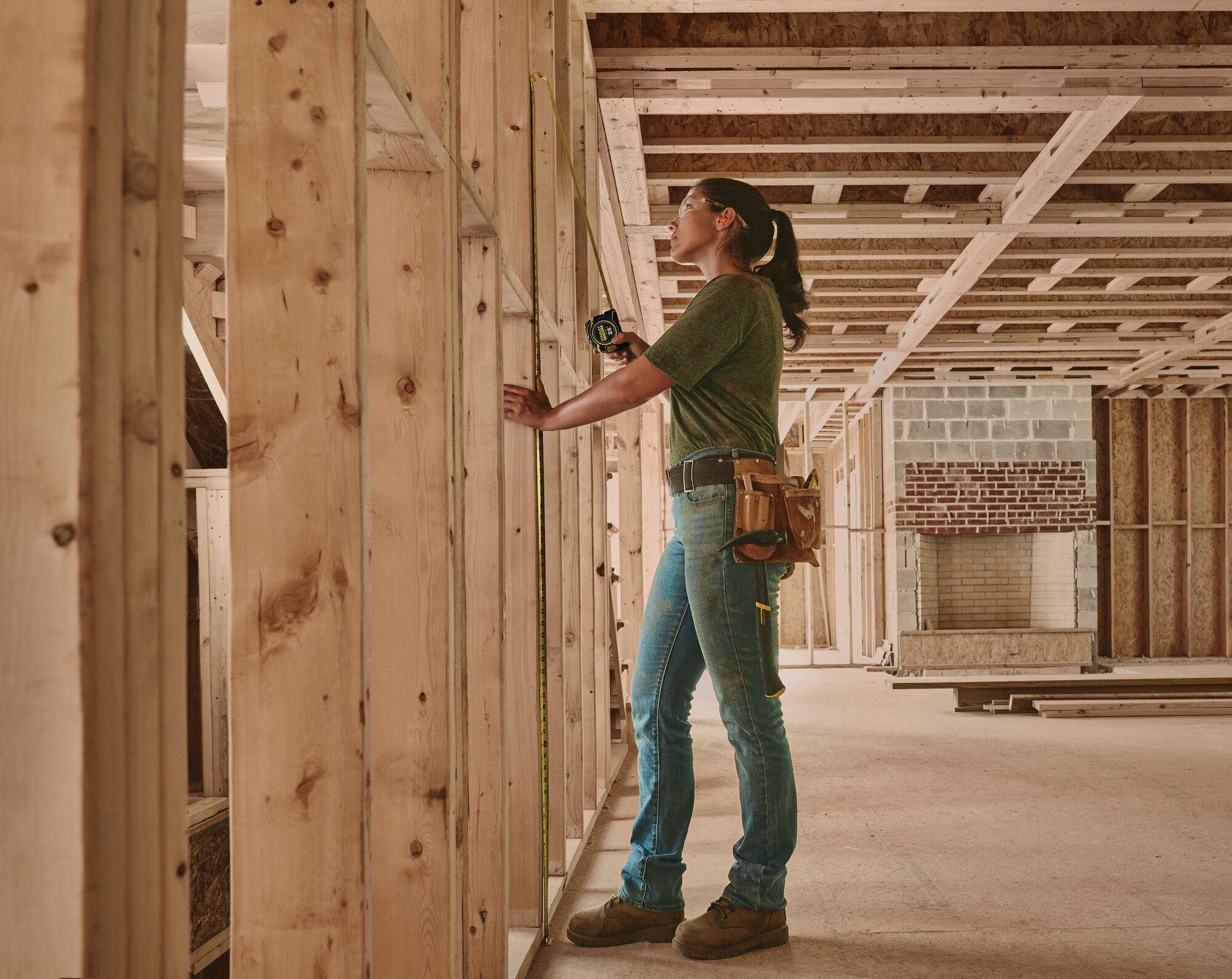 STANLEY FMHT33338 tape measure in use on wooden framing at construction site, side angle.